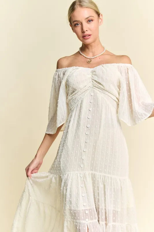  The swiss dotted pattern adds a whimsical and delicate touch to the dress. The ruched detailing creates a figure-flattering silhouette. 